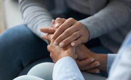 A woman holding hand of another woman